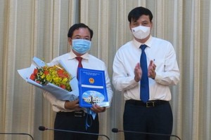 市人委會副主席黎和平（右）向黎國俊同志頒授人事委任《決定》。（圖源：梅花）