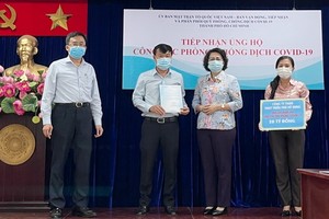 市越南祖國陣線委員會主席蘇氏碧珠(右二)接受富美興發展責任有限公司捐款給購買新冠疫苗防疫基金。