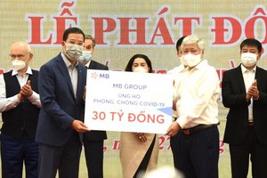 MB集團代表人象徵性向越南祖國陣線中央委員會新冠疫苗基金捐贈的300億元。（圖源：VGP）