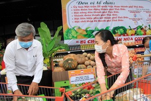 市越南祖國陣線委員會副主席潘嬌清香(右)為市民選購食品。