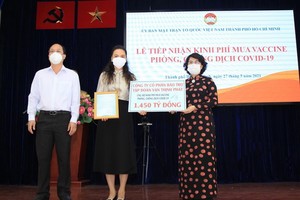 本市市委副書記阮胡海（左）與市越南祖國陣線委員會主席蘇氏碧珠（右）接受萬盛發集團捐助購買疫苗的一萬四千五百億元善款。
