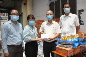 穗城會館理事長盧耀南(右二)和副理事長林海泉(右一)向坊領導移交支持防疫物資和現金。