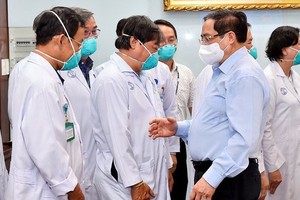 2021年5月13日，政府總理范明政（前右）向市大水鑊醫院的守崗醫護隊伍致以誠摯的問候。（圖源：VGP）