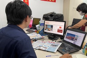 讀者通過華文《西貢解放日報》網報了解新聞。