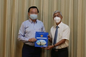 黎鴻山（左）同志從市人委會副主席武文歡手中接過人事委任《決定》。（圖源：孟和）