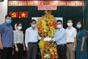 市委民運處副主任吳文倫(左三)向本報編委文忠孝(右三)贈送鮮花。