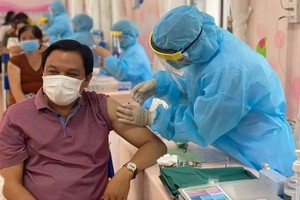 醫護人員為人民注射疫苗。