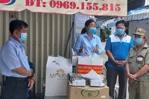 阮氏白梅同志向第十一郡第十三坊防疫一線工作人贈送禮物。