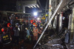 6月27日，在孟加拉國首都達卡，救援人員在建築爆炸現場搜尋倖存者。（圖源：新華社）