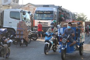 人們在守德集散市場附近搬運貨物。（圖源：黃安）