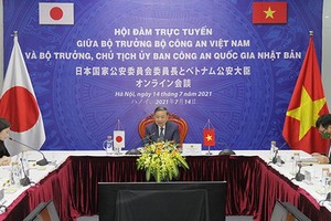 公安部部長蘇林大將（中）以在線方式同日本國家公安委員會委員長棚橋泰文舉行會談。（圖源：越通社）