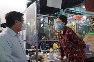 7月18日上午,市人委會主席阮成鋒（左）親往視察第十一郡平泰街市復業情況。（圖源：VNN）