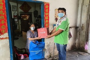 第八郡越南祖國陣線委員會代表贈送禮物給對革命有功華人家庭。