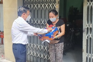 市委民運處主任阮友協向華人貧窮邊緣戶贈送援助品。