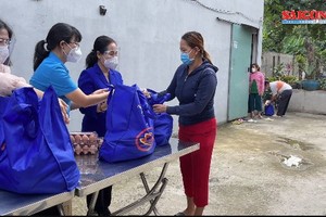 市人民議會主席阮氏麗（右二）向古芝縣受新冠肺炎疫情影響的工人與勞動者贈送禮物。（圖源：視頻截圖）