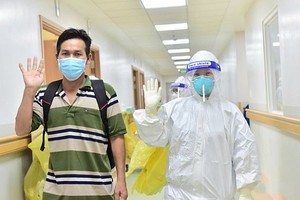 醫護人員送一名新冠肺炎康復者（左）出院。（圖源：緣潘）