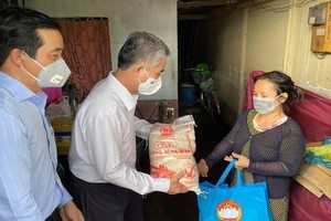 市人委會副主席吳明洲向第八郡遇困民戶贈送援助品。