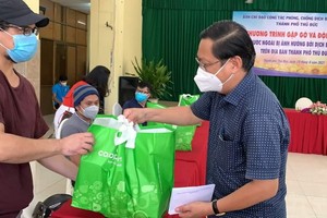 守德市越南祖國陣線委員會主席陳友福向外籍人贈送禮物。