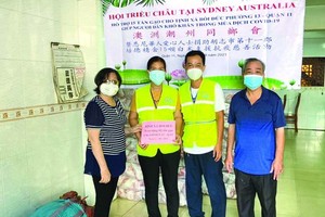 培德精舍副會長曾碧湄和總務張國樑代表向第十一郡第十三坊移交濟貧大米。