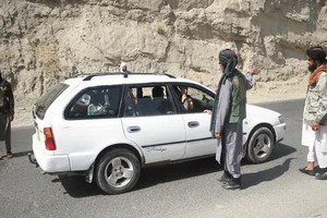 塔利班成員在阿富汗喀布爾的關卡檢查過往車輛。（圖源：新華社）