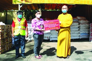 釋慧功法師向丁氏儒副主席轉贈救濟品。