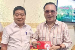 春聚上，何德明（左）向團員發送獎品。