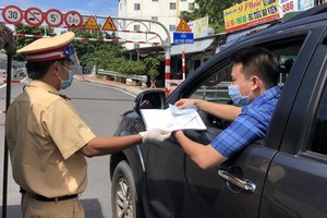 職能力量在新冠疫情防控監察站檢查司機的證件。