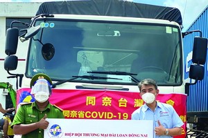 吳明穎會長（右）向展邦縣代表轉贈物質。