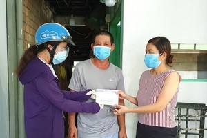 “一家庭幫助一家庭”行動代表人向黎文昆(家住平盛郡第二十八坊)贈送輔助金。