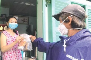 華人攝影家柯成智達派藥品給居家隔離和治療的確診者。