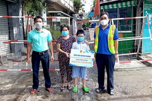 市少先隊委員會和熱心人士配合向貧困學生贈送助學金和禮物。