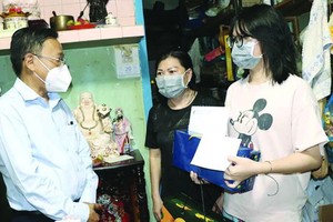 市委民運處主任阮友協看望第五郡受疫情影響的少兒。