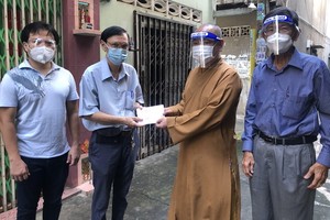 市華人佛教代表釋慧功(左三)與麒麟(左一)向平泰華文中心教務主任許少宏贈送慰問金。