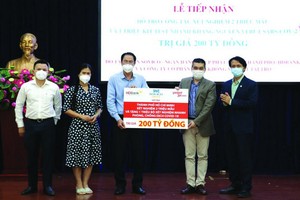 市越南祖國陣線委員會常務副主席阮成忠(左三)接收捐款與頒贈感謝狀。