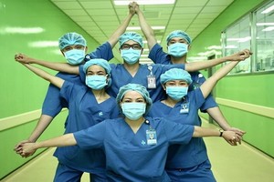 醫護人員傳遞“全國上下團結一心是防疫關鍵”理念。