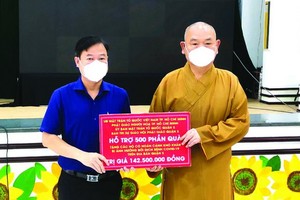 黎晉才主席接受釋慧功法師轉交的物資。