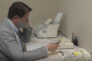 圖為聯辦內的工作人員與朝通話。（圖源：韓聯社）