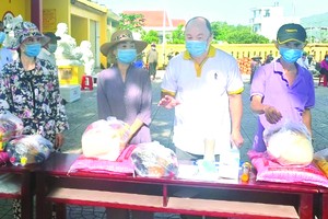 芽莊廣東會館理事長鄭成龍向貧民派發糧食。