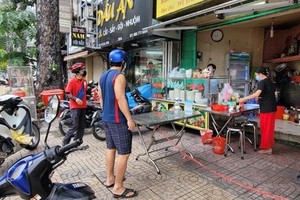 民眾在明記飯館（位於第五郡第八坊陳富街391 號）購買食品。