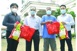 本報編委文忠孝(右一)與“西堤華人文化陳列室”計劃負責人麒麟(左一)向報販贈送禮物。