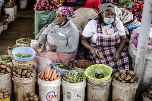 女攤販在肯尼亞一家市場賣蔬菜。（圖源：聯合國）