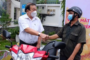 市勞動與榮軍社會廳廳長黎明晉向阮文熱贈送摩托車。