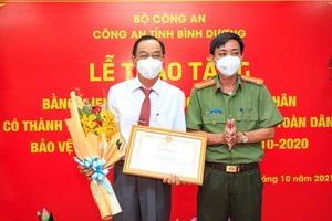 阮全勝主任向陳永安頒發公安部的獎狀。