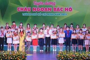 市委副書記阮胡海（前中）向本市模範少兒頒發獎狀。（圖源：紅海）