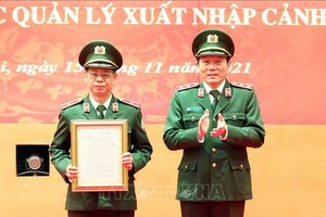 受公安部長委託，公安部副部長梁三光中將向出入境管理局局長郭輝煌少將頒授空中安全科成立《決定》。（圖源：越通社）