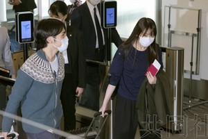 11月14日上午，秋筱宮長女真子手持護照啟程前往美國，左為她的丈夫小室圭。（圖源：共同社）