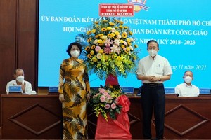 市越南祖國陣線委員會主席蘇氏碧珠（前左）向守德市天主教團結處協商會議贈送鮮花祝賀。（圖源：秋紅）