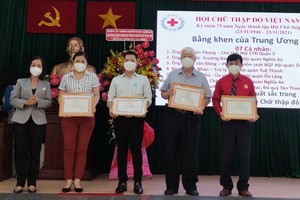 第五郡宣教處主任胡氏竹江向4個人頒發越南紅十字會獎狀。