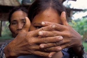 一位母親遮住了女兒的臉，以保護她的身份。女兒在 16 歲時被拐賣。（圖源：UNICEF）