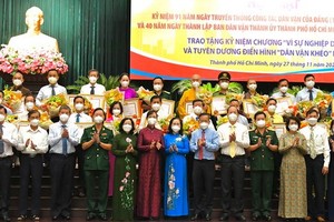 市領導向2021年“能幹民運幹部”典範頒發紀念章並合影留念。（圖源：越勇）